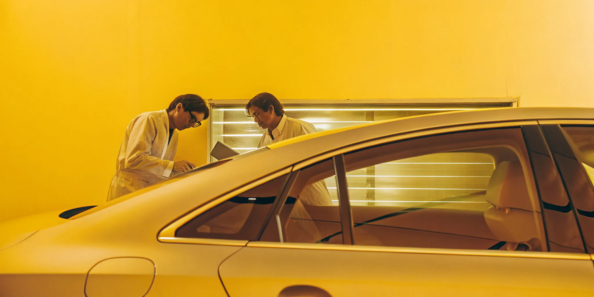 Technicians at an A-1 auto body shop inspecting a car in a modern repair facility.