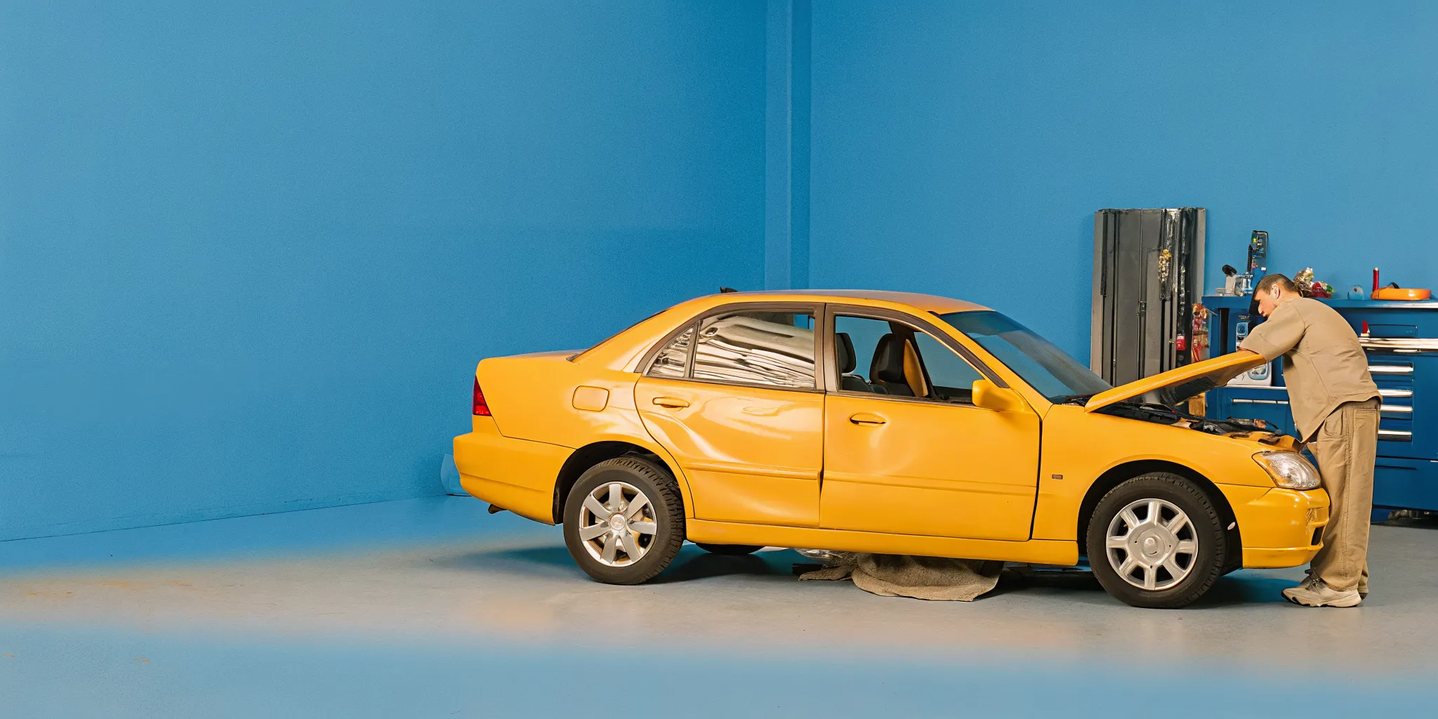 Technician inspecting collision damage on a sedan in Orlando