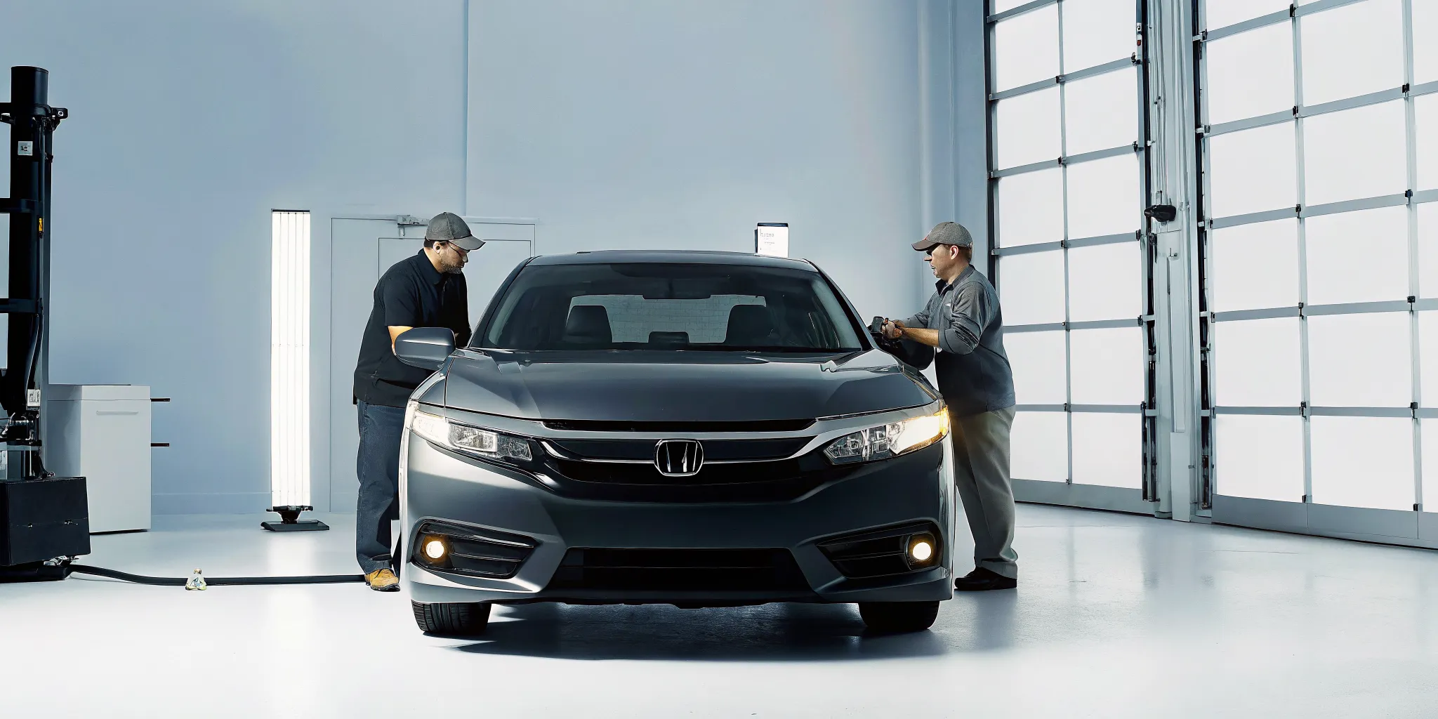 Modern auto body collision repair facility with technicians working on a vehicle in Orlando, Florida