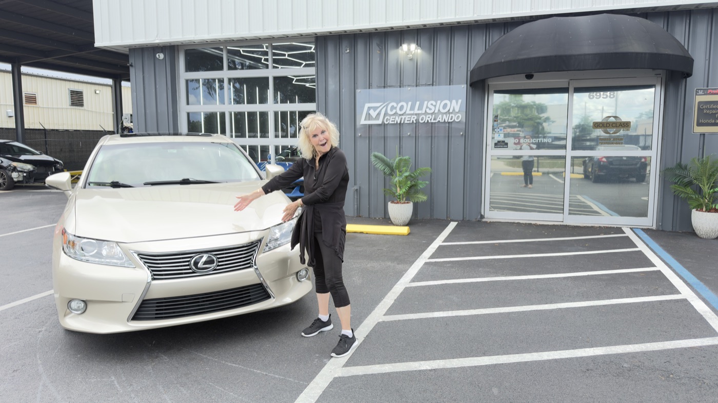 A Collision Center Orlando customer at delivery with her finished vehicle after an insurance repair